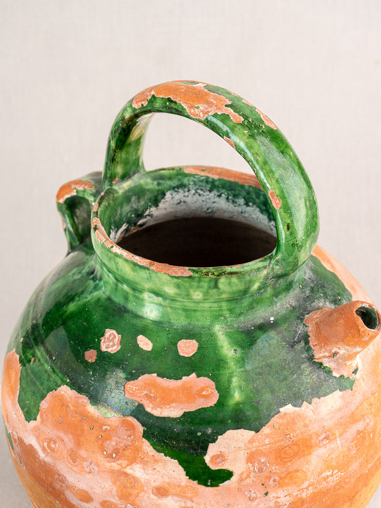 Antique French green glazed earthenware gargoulette with large handle and terracotta showing through worn glaze.