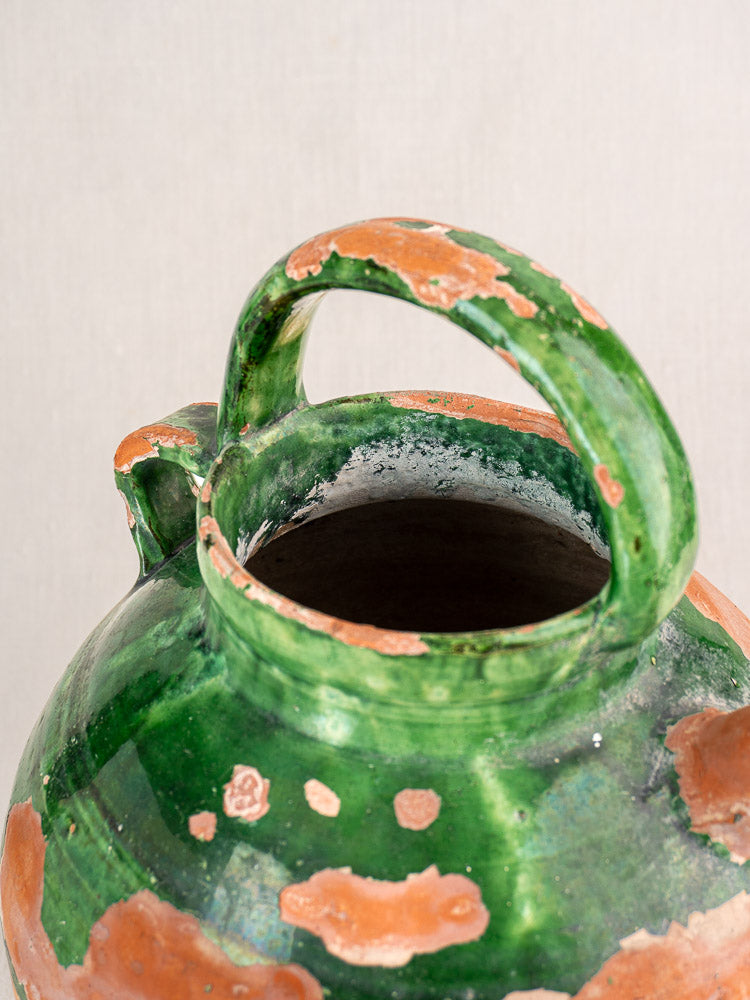 Antique French green glazed earthenware gargoulette with single handle and rustic exposed clay accents.