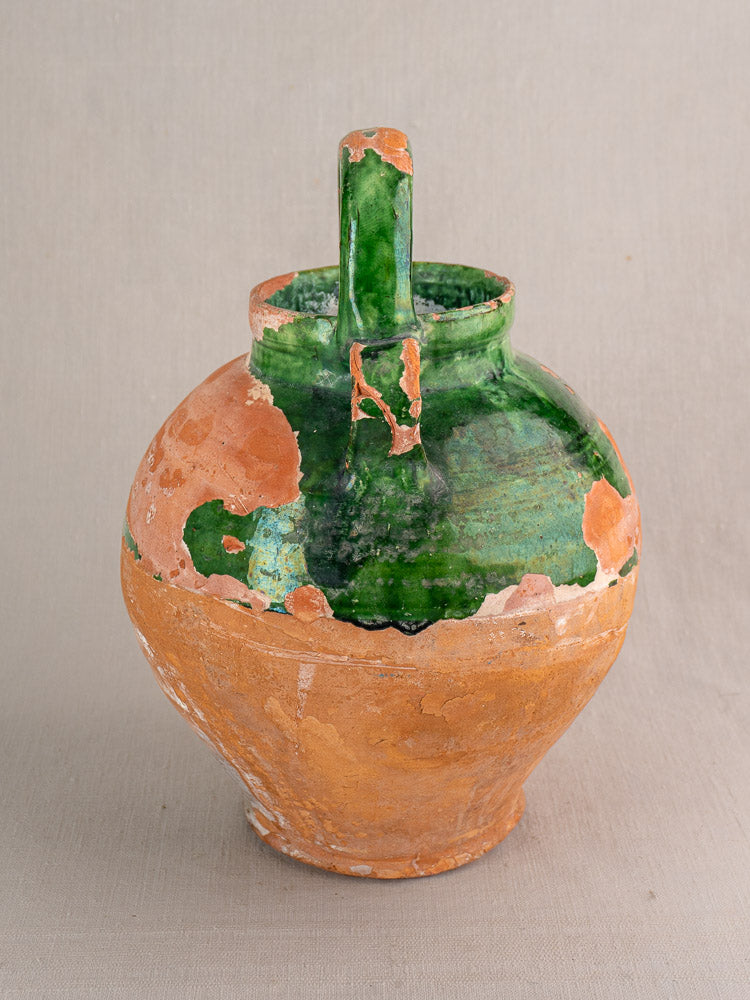 Antique French green glazed earthenware gargoulette with round form, upright handle, and rustic unglazed brown lower half.