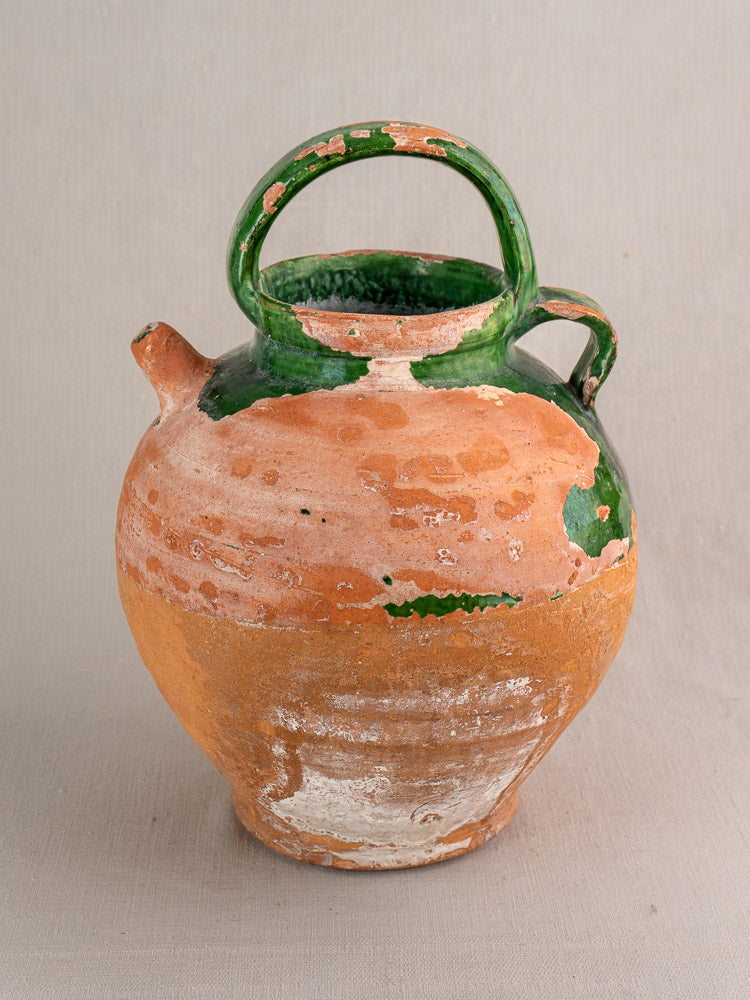Antique French terracotta Gargoulette water jug with green-glazed top, side and top handles, wide spout, neutral background.