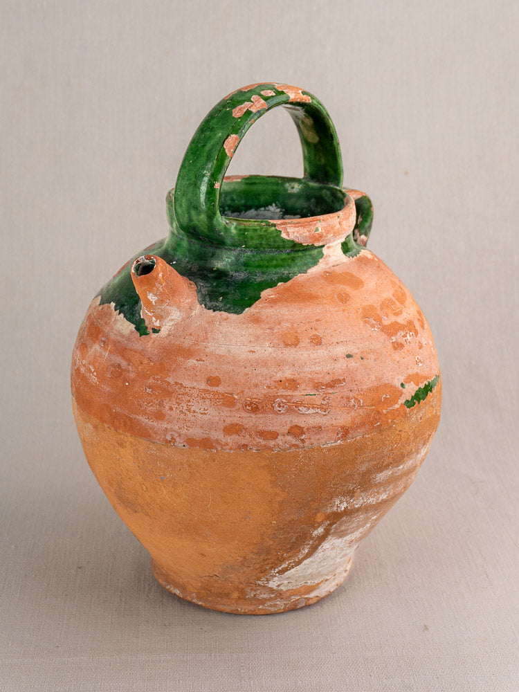 Antique French gargoulette, rustic round earthenware jug with green-glazed handle, terracotta body, and vintage worn green accents.