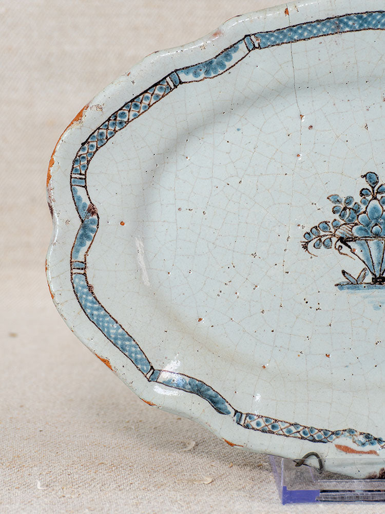 18th-century French faience platter with scalloped edges, blue border, floral motifs, fine glaze crackling, and rim wear.