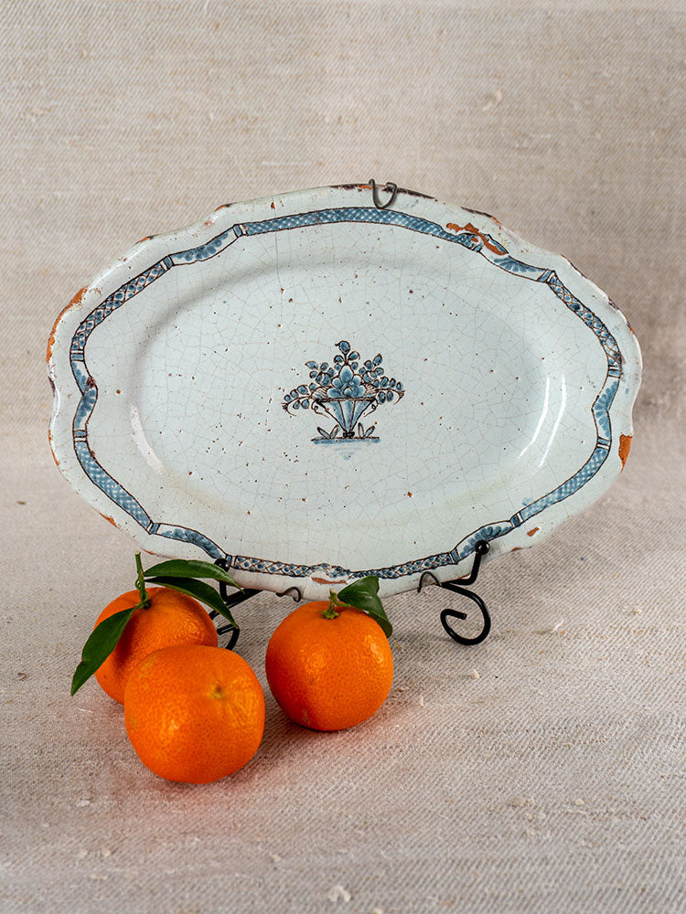 Antique French faience platter, Cul Noir, 18th century, blue floral design, worn edges; tangerines with leaves in front.