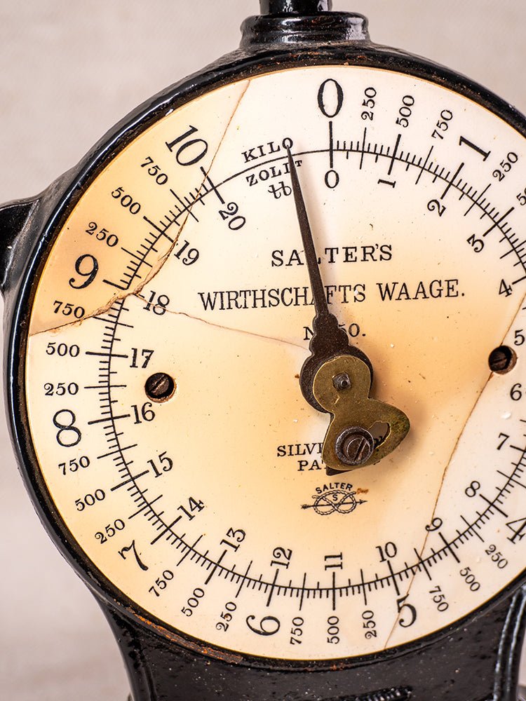 Antique Salter kitchen scale with cast iron details, worn dial, visible numbers, and vintage patina.