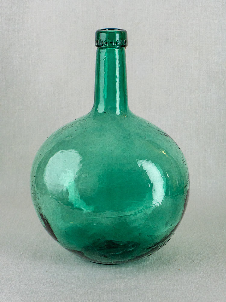 Set of three antique hand-blown Spanish green glass demijohns with rounded bodies and narrow necks.