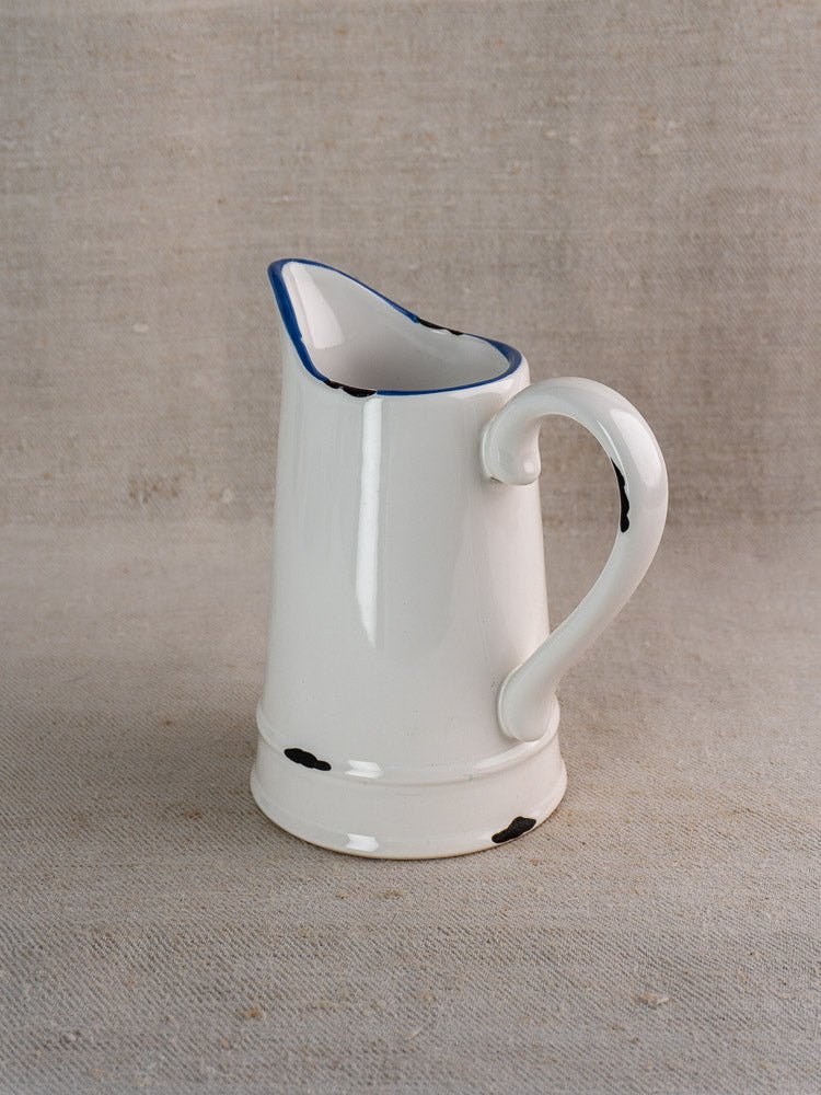 French faience pitcher in white ceramic with blue rim and handle, scuffed base for character.