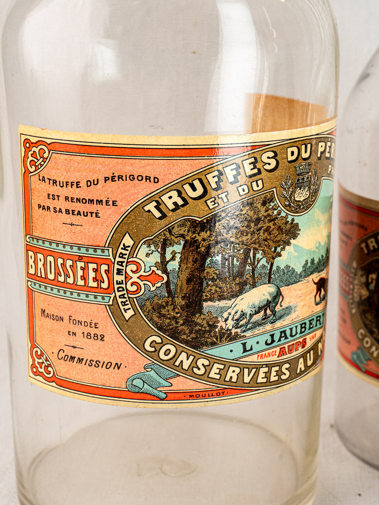 Set of three antique French L. Jaubert glass truffle jars with ornate illustrated labels, circa 1900.