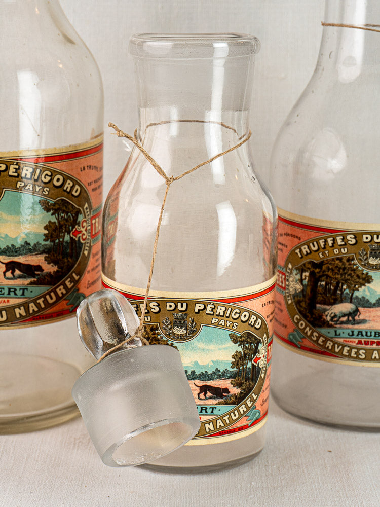Antique French L. Jaubert truffle jars with colorful countryside labels and frosted glass stopper.