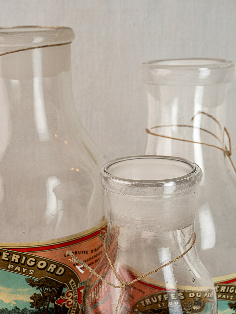 Three antique French L. Jaubert truffle jars, circa 1900, in clear glass with original labels and twine.