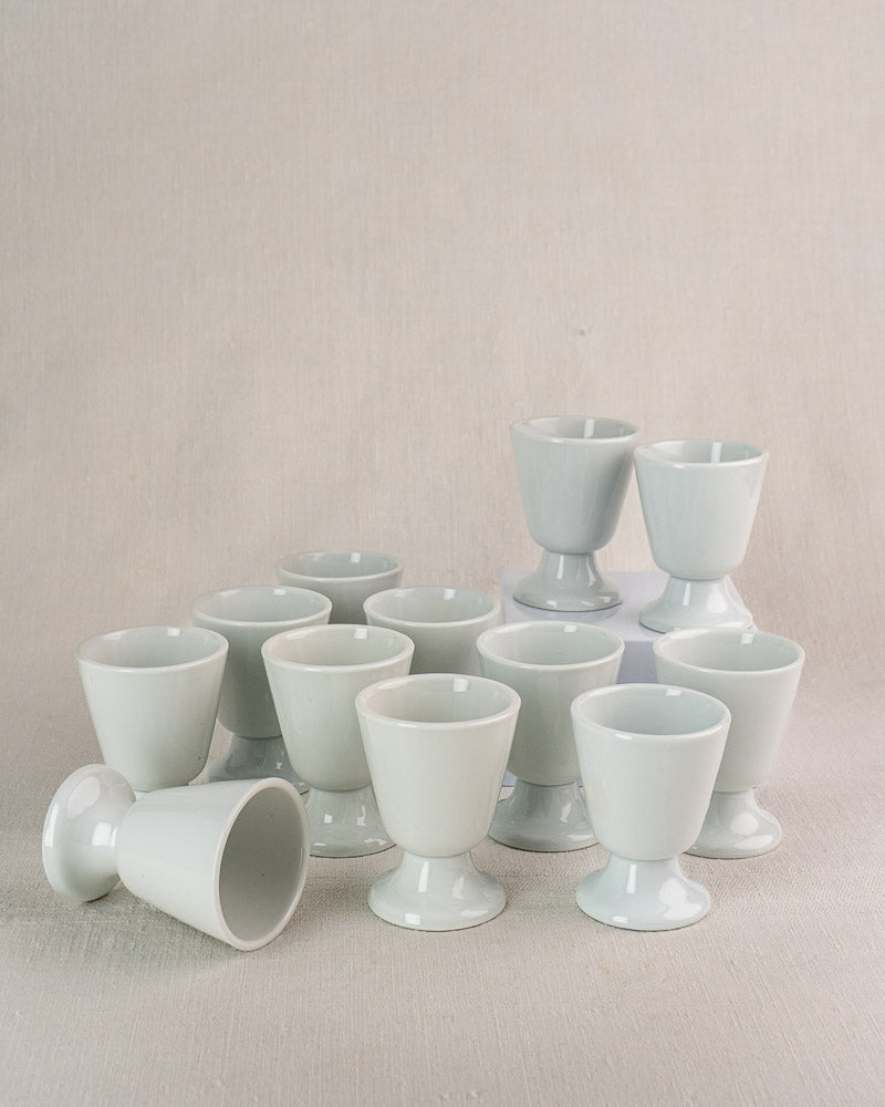 Set of twelve vintage French porcelain mazagran coffee cups by CNP Tradition France, one lying on side.