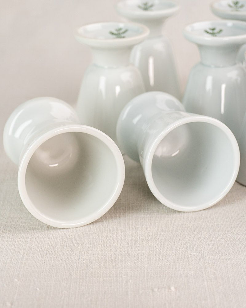 Set of 12 vintage French porcelain Mazagran coffee cups by CNP Tradition, displayed on neutral fabric.