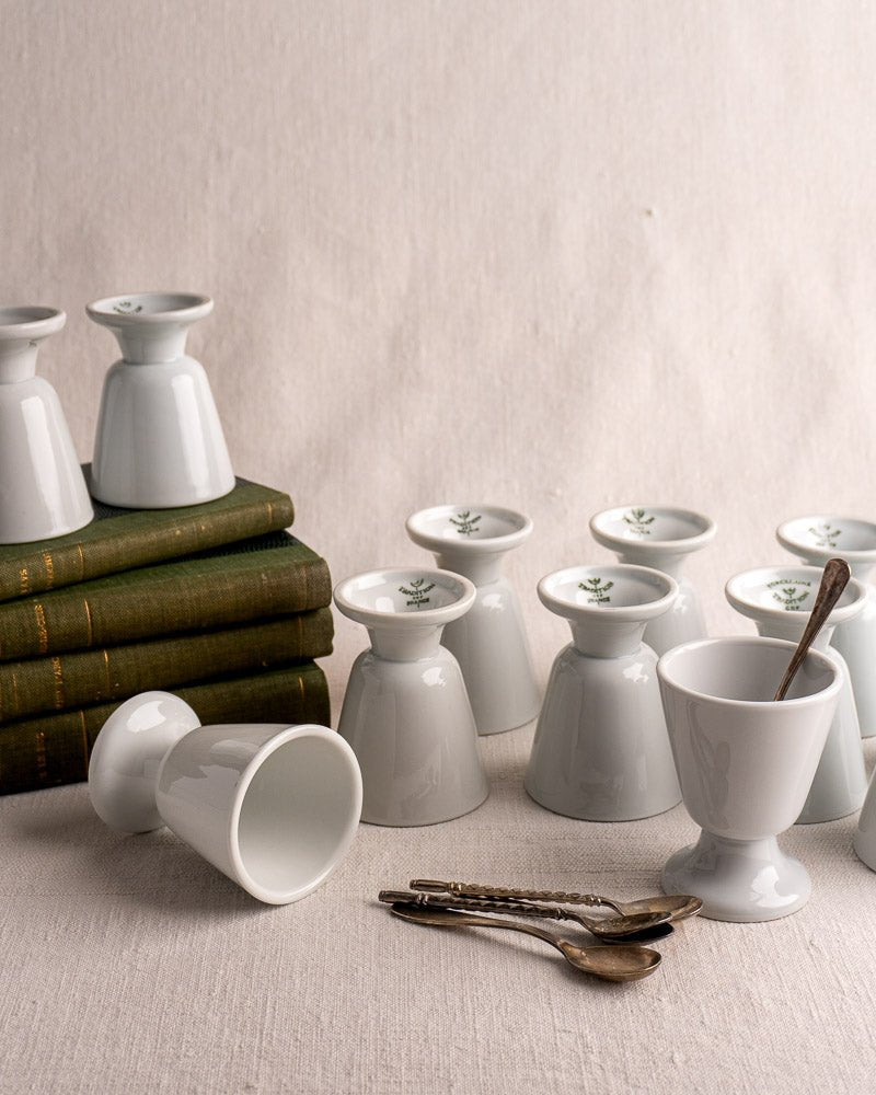 Set of twelve vintage French porcelain Mazagran coffee cups by CNP Tradition France with silver spoons and books.