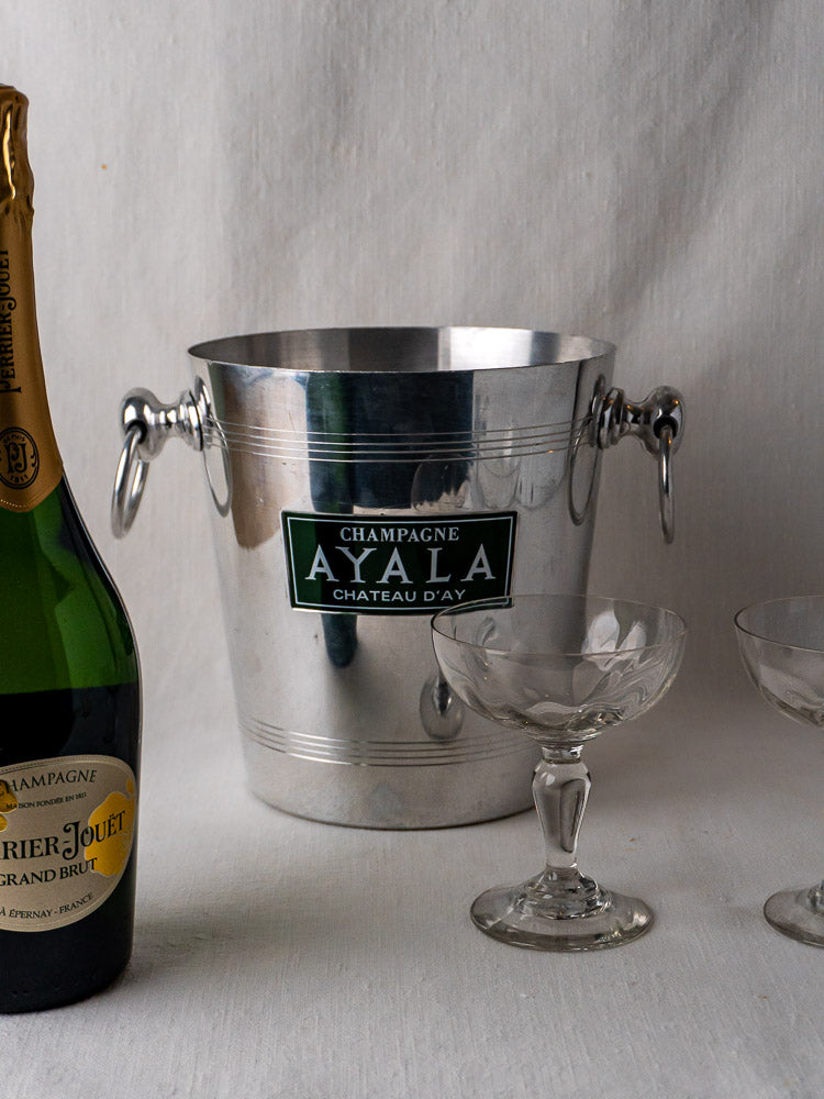 Vintage French Argit aluminum champagne bucket with Perrier-Jouët bottle and coupe glasses on white surface.