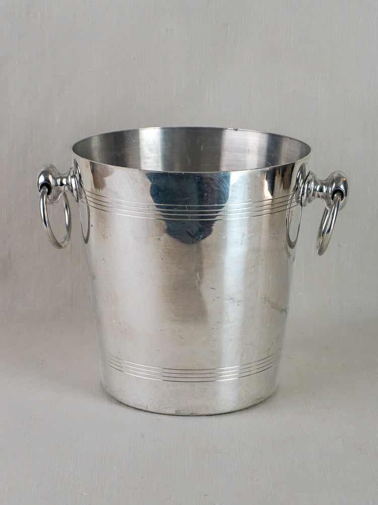 Vintage French Argit Ayala champagne bucket, shiny aluminum with dual handles, on light background.