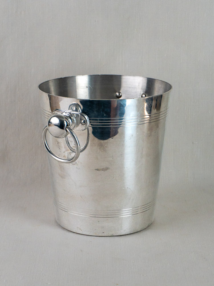 Vintage French Ayala Champagne bucket by Argit in shiny silver aluminum with round side handles on light surface.