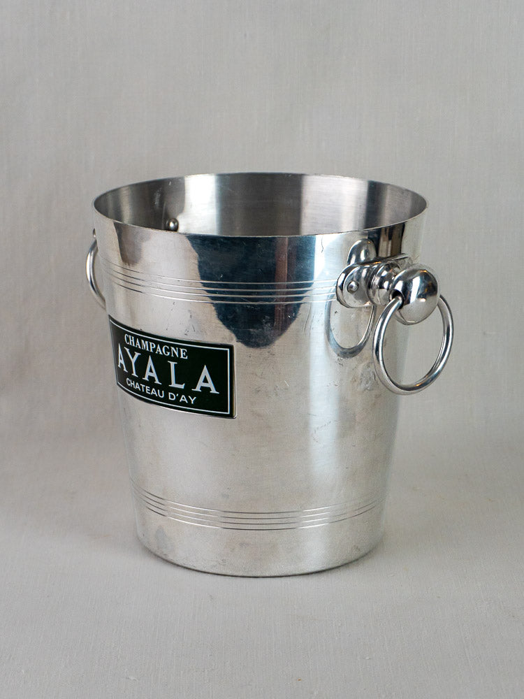 Ayala vintage French champagne bucket in silver-tone aluminum with side handles and black front label.