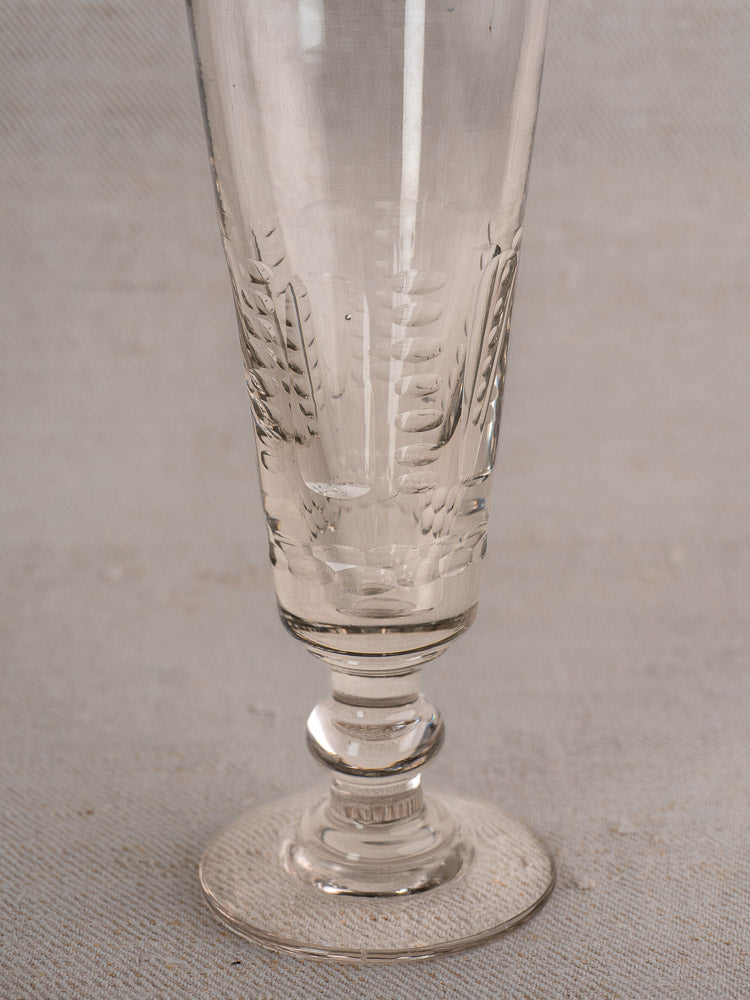 Set of six antique French uranium glass beer flutes with vertical patterns, Belle Epoque style, on a neutral background.