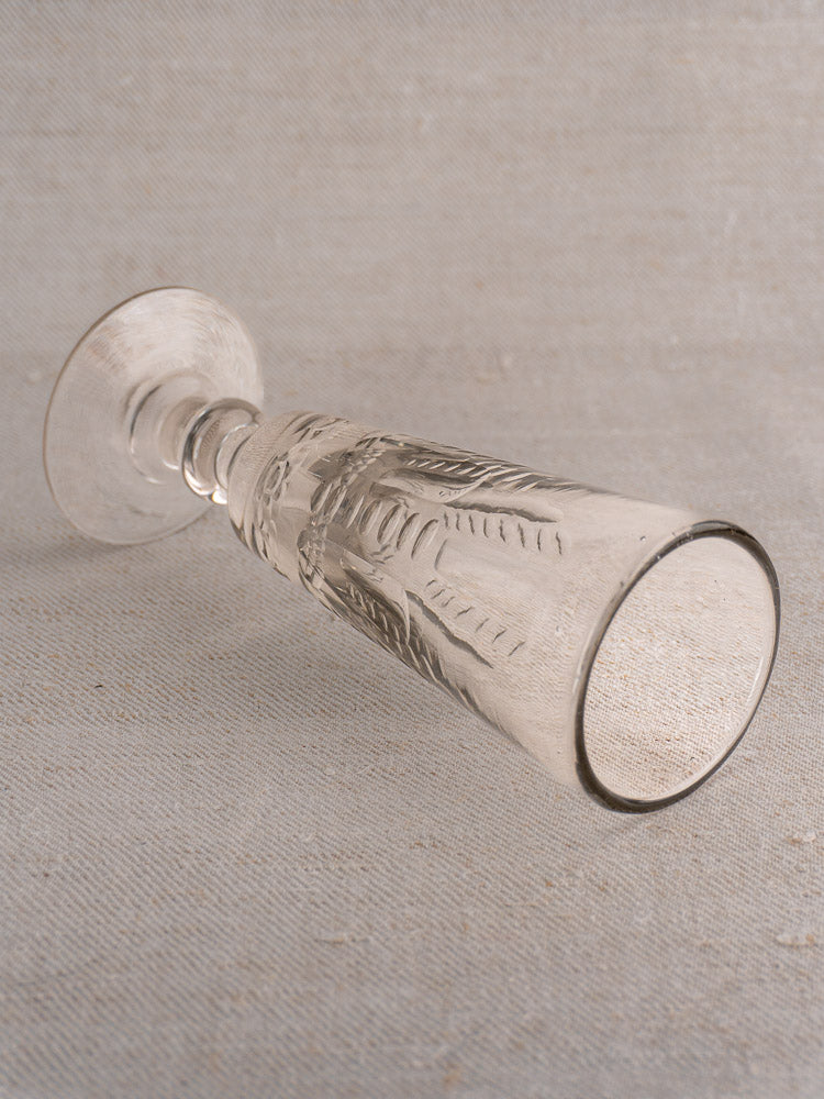 Set of six antique French uranium glass beer flutes c.1900 on light beige textured fabric surface.