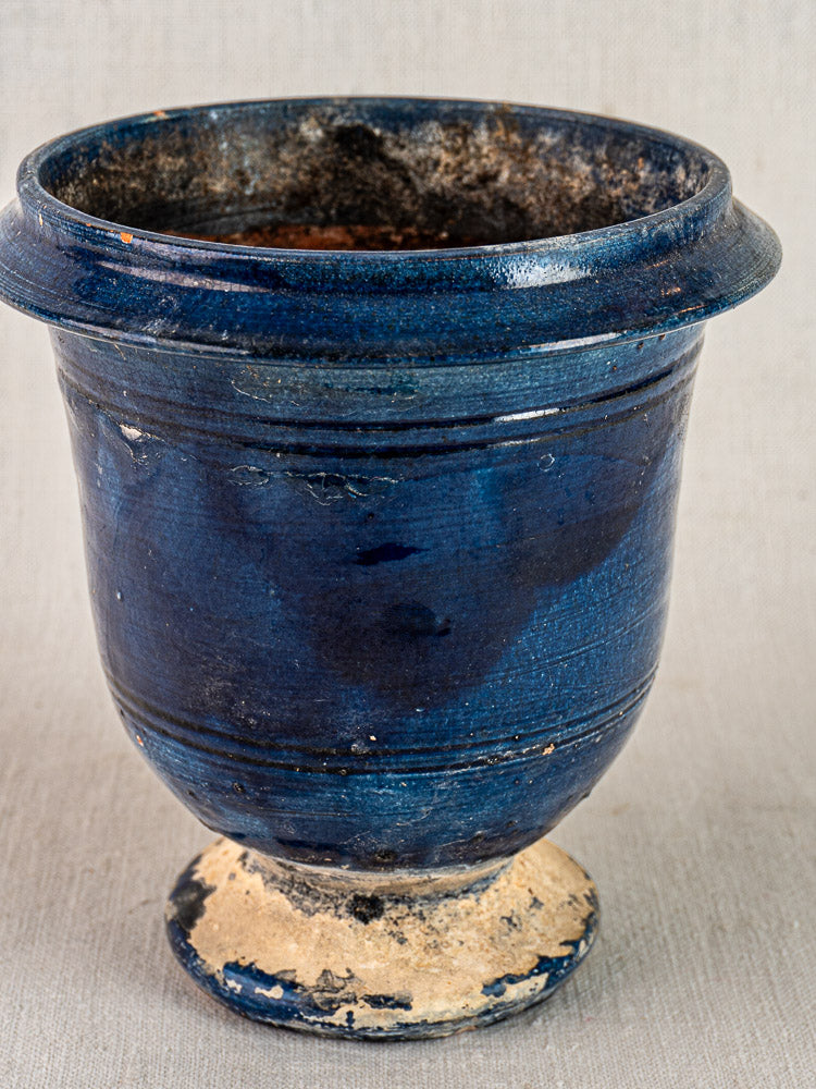Blue glazed antique French Medici terracotta vase with wide rim, rounded body, and visible chips from use.