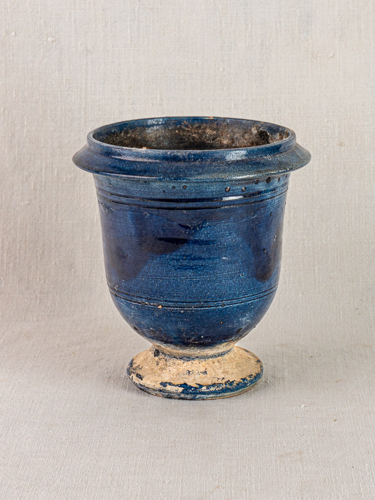 Antique French Medici blue glazed terracotta vase with wide rim and ivory base on light gray background.