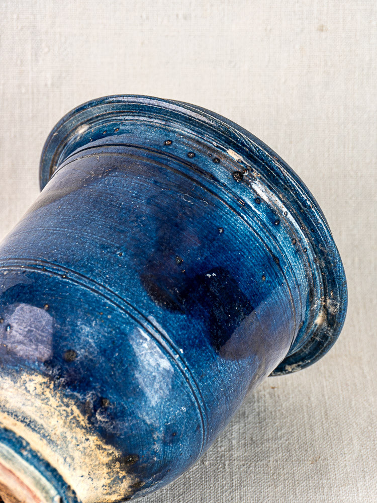 Antique French Medici Vase with blue glazed terracotta, crackle finish, and ridged rim on textured fabric background.