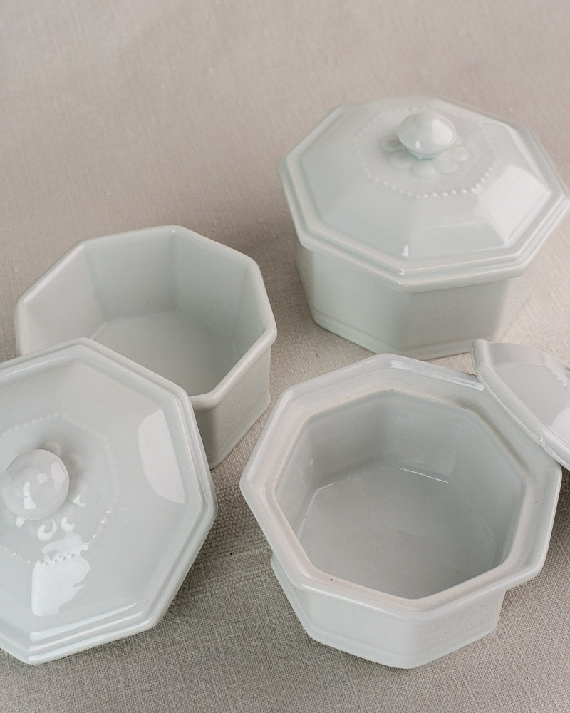Set of three white octagonal Apilco Modèle de José porcelain dishes on beige fabric.