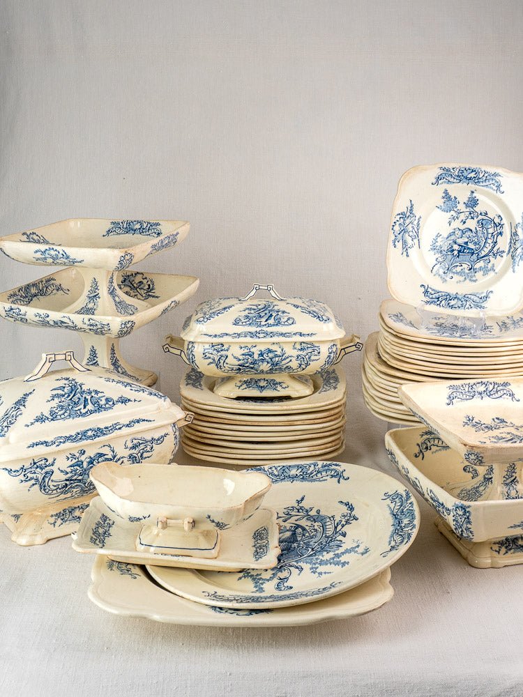 40-piece antique French Clairefontaine faience dinnerware set with blue floral motifs on white ceramic.