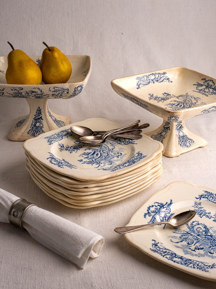 Antique French Clairefontaine faience service, blue and white plates with pears, silver spoons, on fabric.