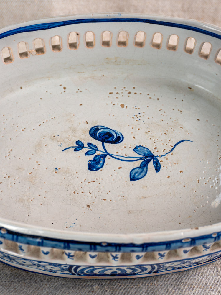 Antique French faience jardinière with cobalt blue glaze, floral center, rim cutouts, speckled accents, and aged patina.