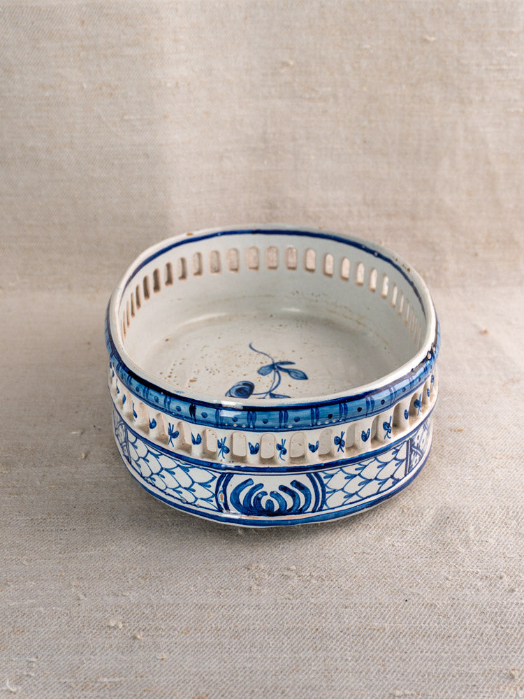 Antique French faience jardinière, round and shallow with cobalt blue floral motifs, openwork rim, white base on neutral fabric.