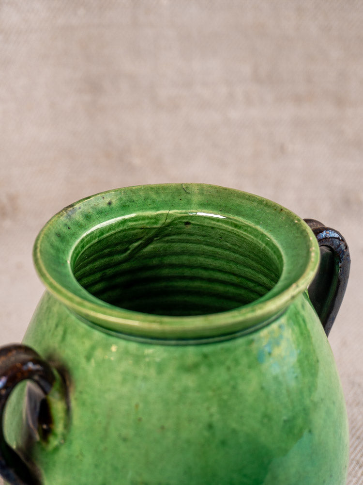 Antique French Dieulefit green earthenware olive pot, early 20th century, dark handles, ribbed rim, cracked lip.