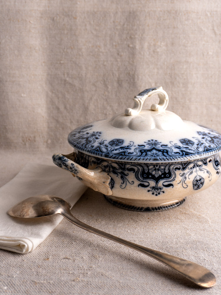 Antique French Badonviller Étoile covered serving dish with blue floral motifs and two handles on a light beige surface.