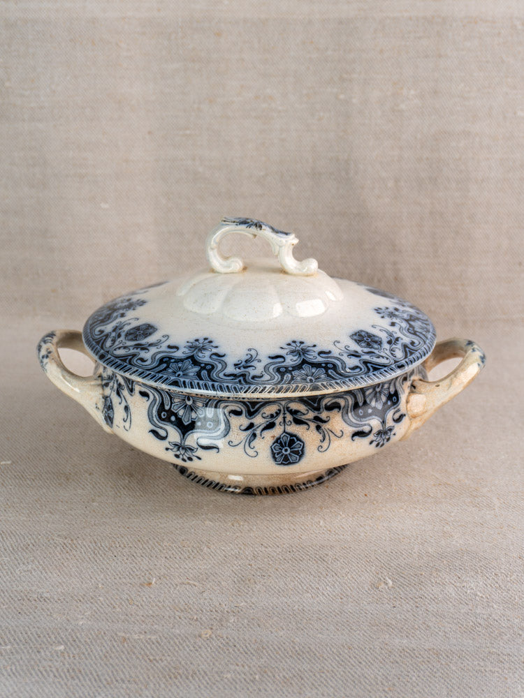 Antique French Badonviller Étoile covered serving dish with blue floral motifs and two handles on a light beige surface.