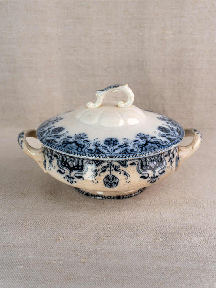 Antique French Badonviller Étoile covered serving dish, circa 1900, with blue floral motifs and side handles on beige fabric.