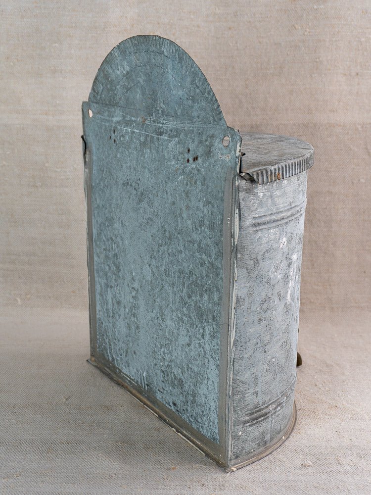 Antique French zinc lavabo reservoir with brass tap, rounded lid, patina, on neutral fabric.
