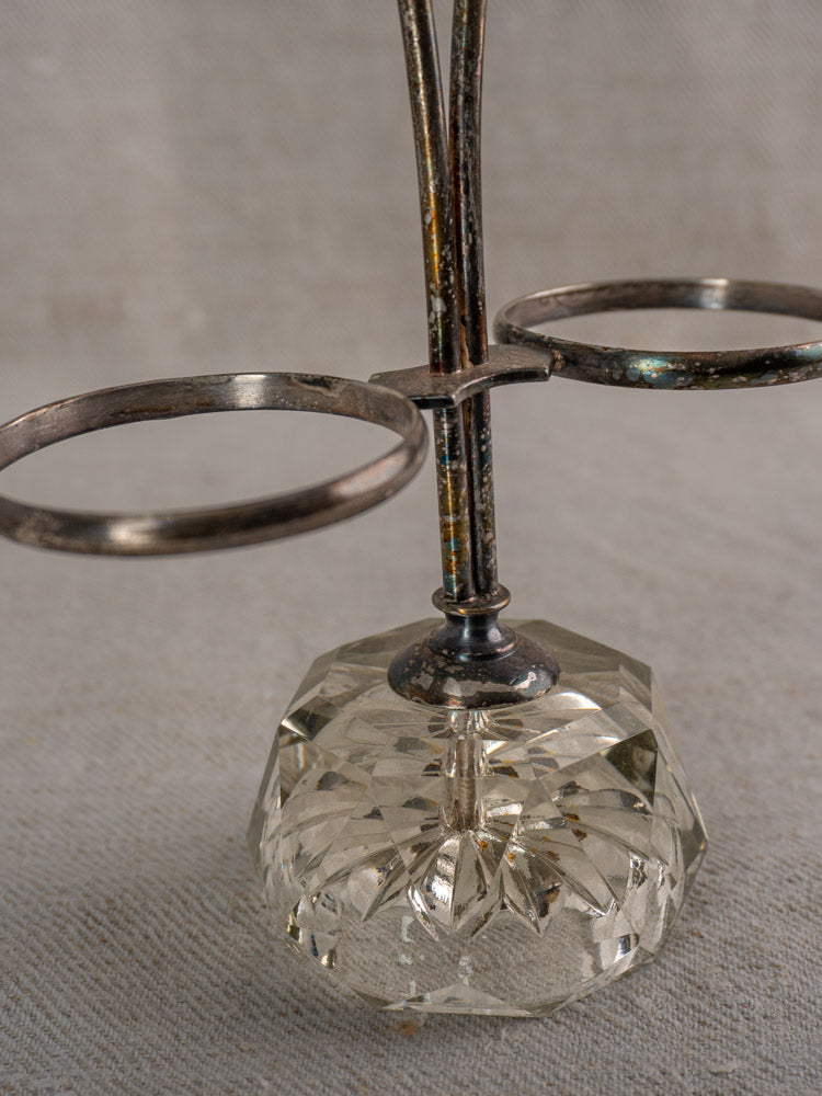 Antique French silver plate and cut glass condiment server with dual holders on textured beige surface.