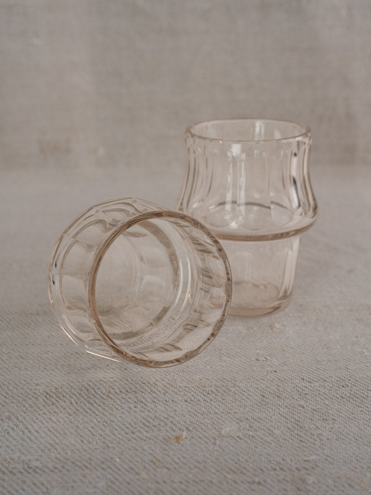 Pair of antique French cut glass condiment jars with silver-plated bases on woven fabric surface.