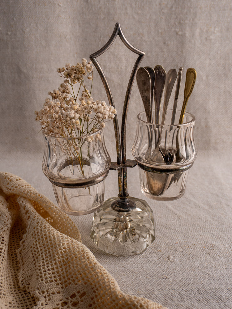 Antique French silver plate and cut glass condiment server with two jars, lace cloth nearby.