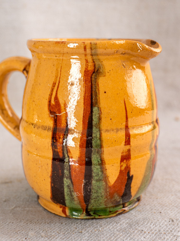 Late 19th-century French Jaspé pitcher, small yellow ceramic with handle, spout, and multicolor slip glaze accents.