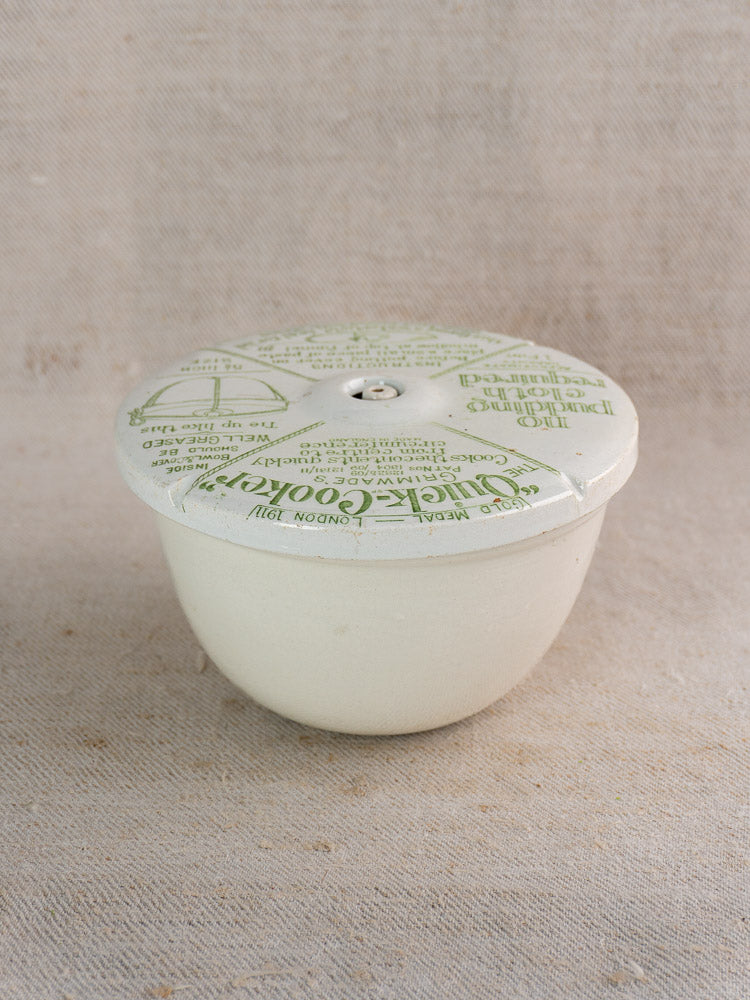 Antique English ironstone pudding steamer marked "Grimwade Quick Cooker" c.1911 on beige linen fabric.