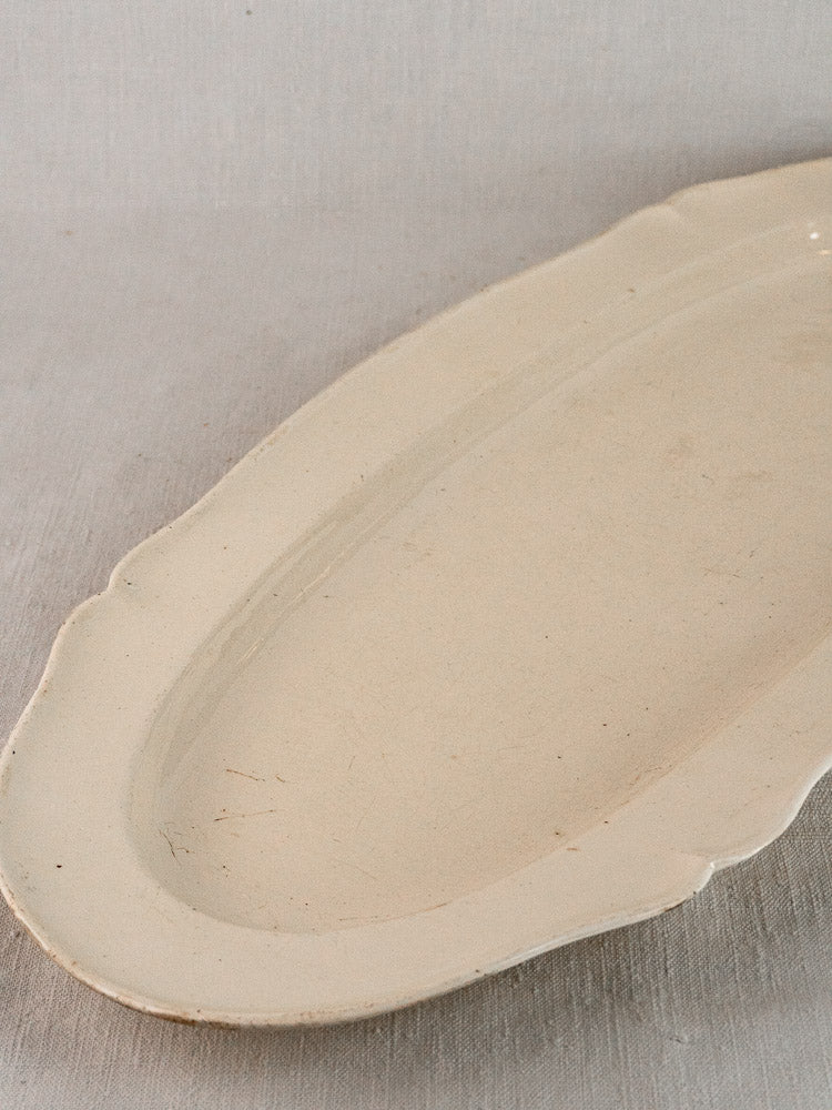 Antique French faience oval meat platter with subtle edging and classic earthenware wear marks.