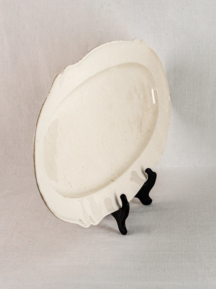 Antique French faience fine grand meat platter from the early 19th century on black stand.