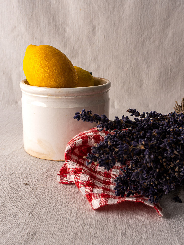 Antique French Fenal Badonviller rillettes pot in white ironstone with lemons, lavender, and checkered cloth.