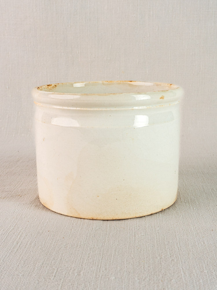 Antique French Badonviller rillettes pot in white ironstone with subtle yellowed patina near base.