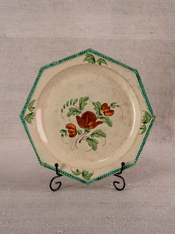 Antique French faience plate, octagonal with green beaded rim and hand-painted red floral design, on metal stand.