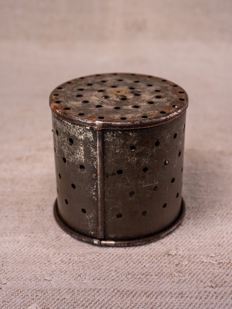 Antique French cast iron fruit press with blue enamel and patina, circa 1900, on beige surface.