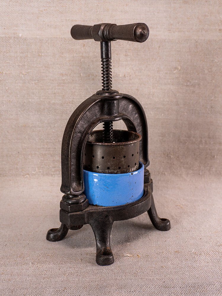 Antique French cast iron fruit press with blue enamel and black legs, circa 1900.