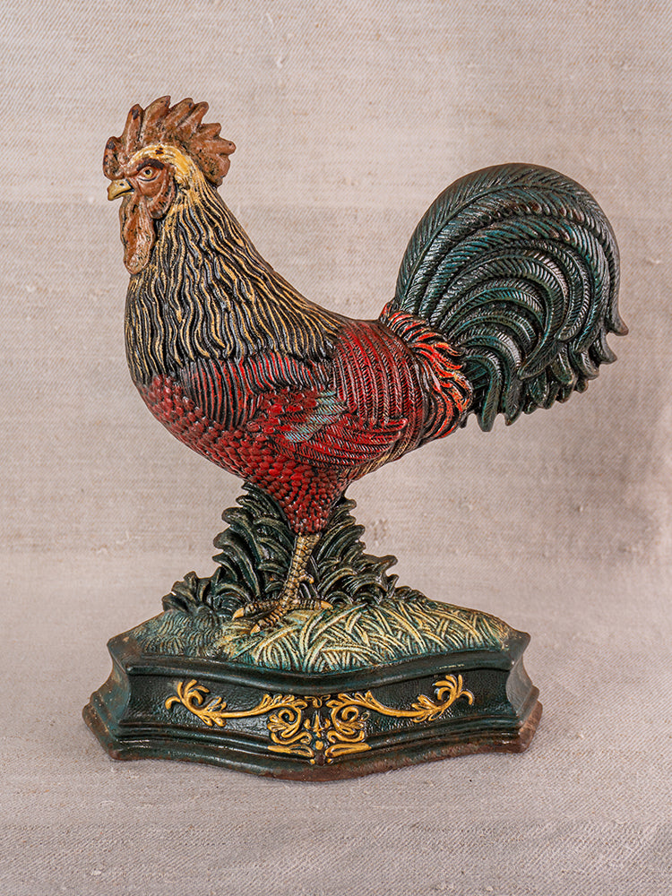 Antique French cast iron rooster doorstop with detailed red, brown, and green feathers on ornate green-gold base.