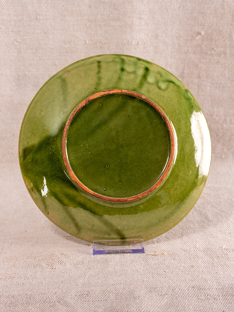Mid-century French green glazed earthenware berry drainer set displayed upside down on clear stand, beige textured fabric backdrop.
