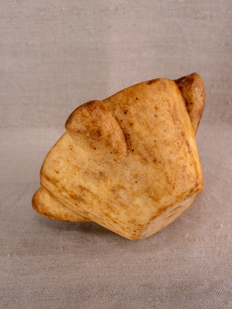 18th-century French marble mortar and pestle with Provencal silhouette on textured beige fabric background.